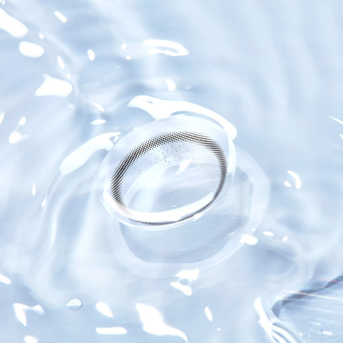 물 위에 떠 있는 렌즈미 컬러 콘택트렌즈 클로즈업 이미지 A close-up of a LensMe colored contact lens floating on clear water