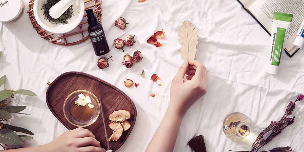 Purito skincare flatlay with herbs and books