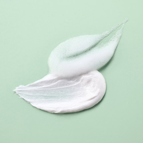연두색 배경 위에 펼쳐진 더 하르나이 클렌저의 텍스처와 거품 컷 Cleanser cream and foam texture on soft green background