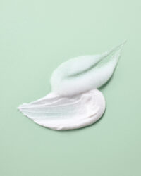 연두색 배경 위에 펼쳐진 더 하르나이 클렌저의 텍스처와 거품 컷 Cleanser cream and foam texture on soft green background