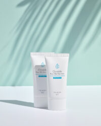 야자수 그림자 아래 놓인 시카이드 순한 자외선 차단제 2종 Cicaide sunblock products under palm leaf shadows on mint blue background