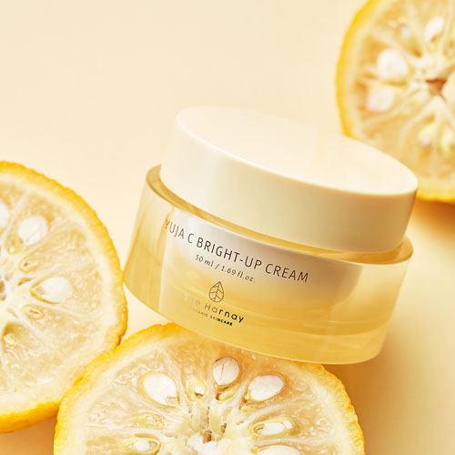 유자 단면과 함께 구성된 더 하르나이 유자C 브라이트 업 크림 제품 이미지 The Harnay Yuja C Brightening Cream displayed with citrus slices on yellow background
