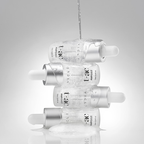 투명 앰플 병 여러 개를 수직으로 쌓고 위에서 액체를 붓는 장면 Several Vicle ampoules stacked vertically while water is poured over them