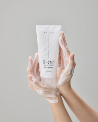 거품이 묻은 손 위에 정중앙으로 세워진 Vicle pH 클렌저 제품 Hands holding Vicle pH cleanser with foam – Vicle skincare photography