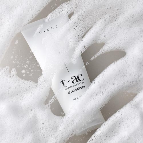 클렌저 제품이 풍성한 거품 아래 반쯤 잠겨 흐릿하게 드러난 연출 컷 Vicle pH cleanser partially submerged in soft foam, blending into the texture