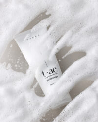 클렌저 제품이 풍성한 거품 아래 반쯤 잠겨 흐릿하게 드러난 연출 컷 Vicle pH cleanser partially submerged in soft foam, blending into the texture