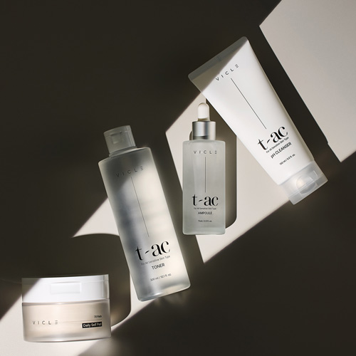 빛의 조각 사이에 정렬된 Vicle 제품 4종 (패드, 토너, 앰플, 클렌저) 이미지 Four Vicle skincare products arranged within distinct shapes of light and shadow