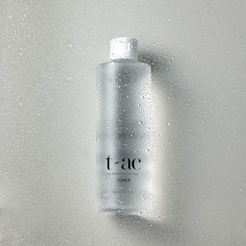물방울이 맺힌 유리창 뒤로 보이는 Vicle 토너 제품 사진 A skincare toner bottle viewed through a foggy, water-beaded glass surface