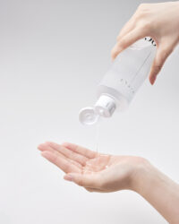한 손으로 토너를 짜내어 다른 손바닥에 덜어내는 제품 사용 장면 A hand pours Vicle toner into the open palm of the other hand in a clean setting