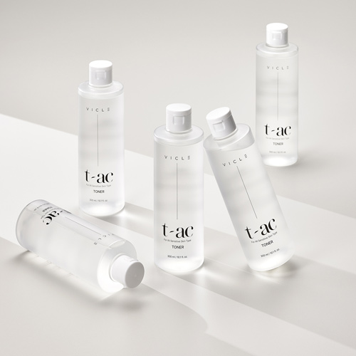 5개의 투명 토너 병이 서로 다른 각도로 정갈하게 배치된 구성 Five clear toner bottles arranged with varied angles and clean shadows