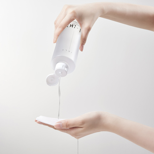 한 손으로 토너 용기를 잡고 다른 손 위의 패드에 액체를 붓는 장면 A visual of Vicle toner being poured from one hand onto a pad held by the other