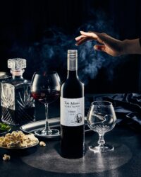 어두운 배경과 연기 속에 손이 와인병을 향해 뻗은 연출 이미지 A dramatic scene of a hand reaching toward a wine bottle surrounded by smoke and deep shadows