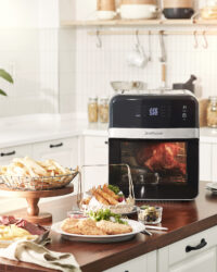 제니퍼룸 에어프라이어에서 조리 중인 로티세리 치킨과 감자튀김, 튀김 요리가 놓인 주방 테이블 세로 뷰 Jenniferroom air fryer with rotisserie chicken, fries, and fried food on kitchen table vertical composition