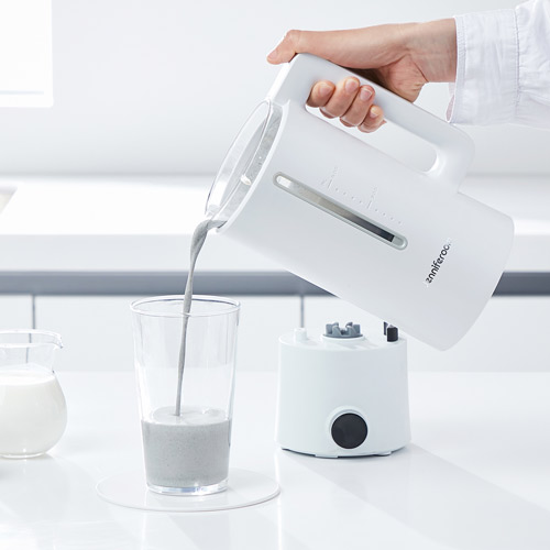 화이트 제니퍼룸 전기포트에서 유리컵으로 음료를 따르는 장면 White Jenniferroom electric kettle pouring fresh beverage into a glass in kitchen setting