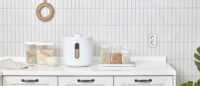 화이트 제니퍼룸 쌀통과 다양한 곡물 보관 용기가 주방에 배치된 모습 Product photo of white Jenniferroom rice container with various grain storage jars in a kitchen setting