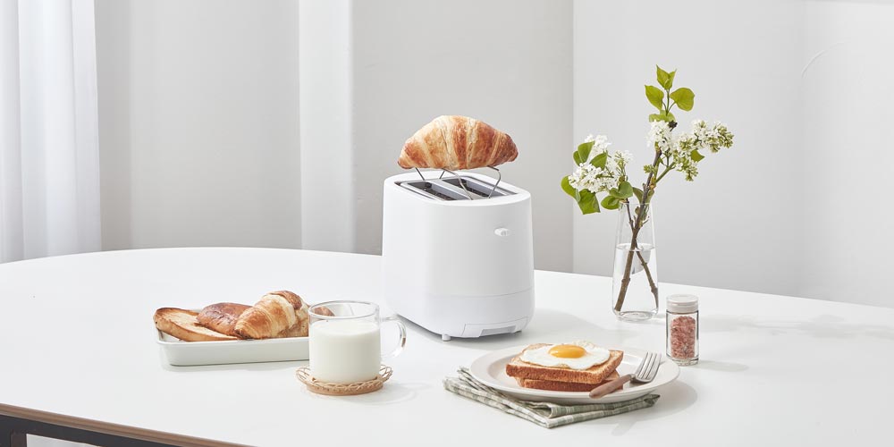 화이트 제니퍼룸 토스터와 크루아상, 계란 토스트, 우유가 놓인 아침 식사 테이블 Product shot of Jenniferroom white toaster with croissant, egg toast, and milk on breakfast table