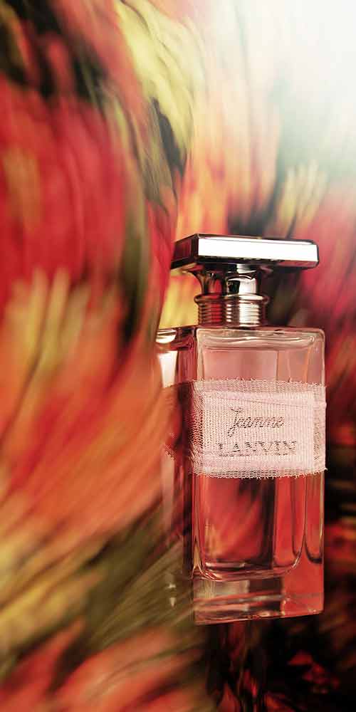 붉은 배경 속 랑방 잔느 향수 병 클로즈업 이미지 Close-up image of Lanvin Jeanne perfume bottle on a vivid red background
