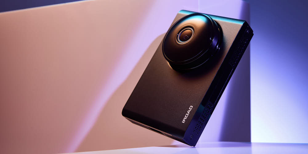 아이로드 블랙박스가 컬러 조명 아래 기울어진 각도로 연출된 제품 사진 A tilted IROAD blackbox dashcam captured with colorful lighting for a modern, stylish mood