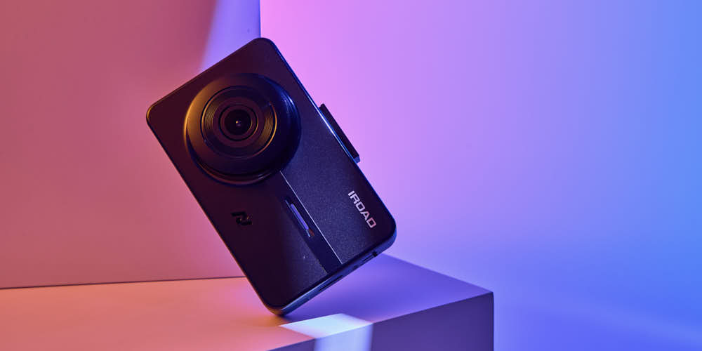 IROAD 블랙박스가 컬러 조명 아래 세련되게 연출된 제품 사진 IROAD dashcam product shot styled with vibrant color lighting
