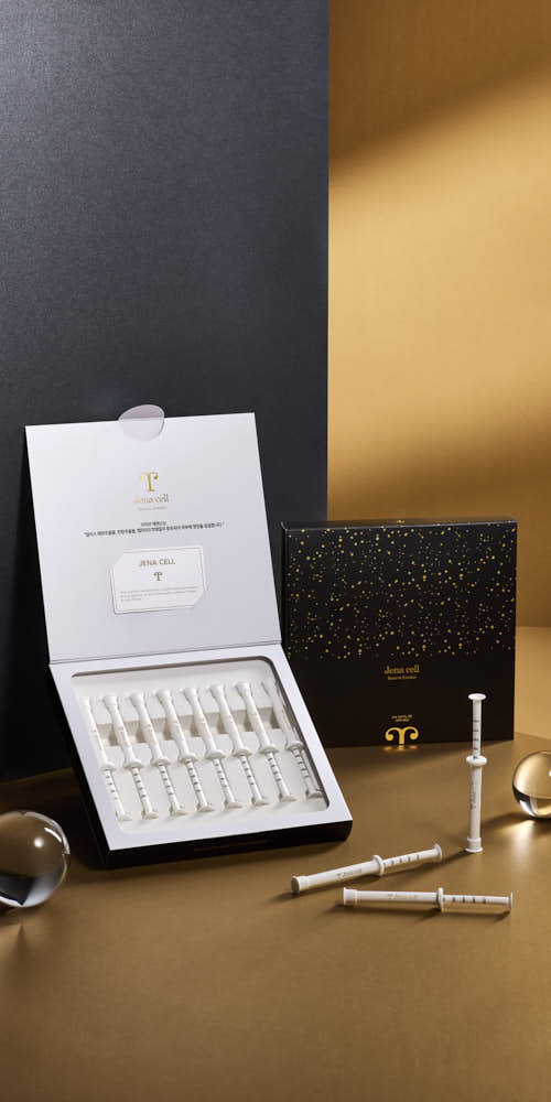 JenaCell 시린지 형태 세럼 제품이 블랙과 골드 패키지와 함께 연출된 이미지 JenaCell syringe-type serum displayed with black and gold packaging