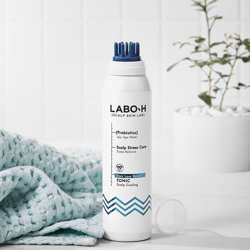 유리 비커와 식물 옆에 놓인 LABO-H 두피 쿨링 탈모 완화 토닉 제품 컷 LABO-H scalp tonic for hair loss relief placed with glass beakers and green leaves