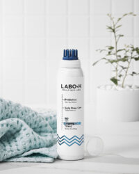 유리 비커와 식물 옆에 놓인 LABO-H 두피 쿨링 탈모 완화 토닉 제품 컷 LABO-H scalp tonic for hair loss relief placed with glass beakers and green leaves