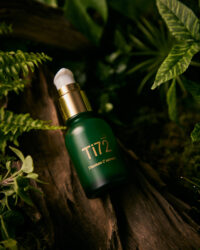숲 속 배경 위에 놓인 휴메디컬 Ti72 세럼 병 제품 사진 Product photo of Humedical Ti72 Titanium C Serum bottle placed in a natural forest background