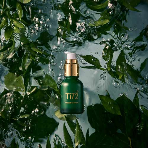 휴메디컬 Ti72 세럼이 물 위에 떠 있는 듯한 장면, 녹색 잎과 어우러진 고급스러운 연출 Humedical Ti72 serum captured floating in water, surrounded by lush green leaves for a luxurious look