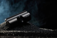 검은 모래 위에 놓인 아이로드 블랙박스 X6 제품 사진 IROAD Dashcam X6 placed on black sand surface