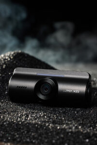 아이로드 X6 블랙박스가 스튜디오 블랙 텍스처 위에 놓인 제품 이미지 IROAD X6 blackbox placed on black studio texture