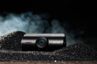 블랙 텍스처 배경에 놓인 아이로드 X6 블랙박스 제품 이미지 IROAD X6 dashcam product on black textured surface