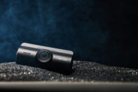 블랙 텍스처 배경 위에 놓인 아이로드 X6 블랙박스 제품 사진 IROAD X6 dashcam photo on black textured surface