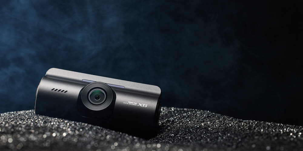 블랙 텍스처 배경 위에 놓인 아이로드 X6 블랙박스 제품 사진 IROAD X6 dashcam photo on black textured surface