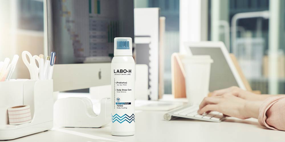 책상 위에 놓인 라보에이치 두피 토닉 제품 사진 Labo-H scalp tonic product placed on office desk