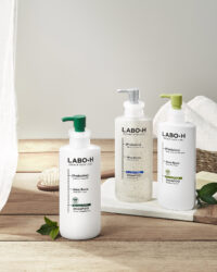 라보에이치 샴푸 세 가지 제품이 함께 놓인 패키지 사진 Photo of LABO-H shampoo triple pack on a wooden table