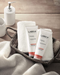 라보에이치 탈모케어 트리트먼트 듀오, 바구니와 수건 배경의 제품 컷 Labo-H hair loss relief treatment duo with basket and towels in clean bathroom styling